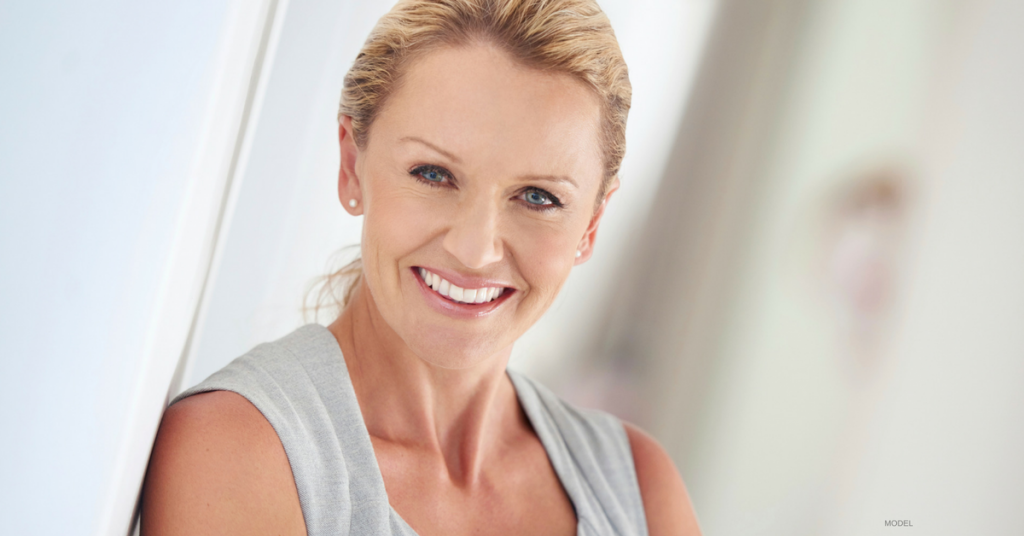Face of attractive middle-aged blonde woman with hair pulled back smiling
