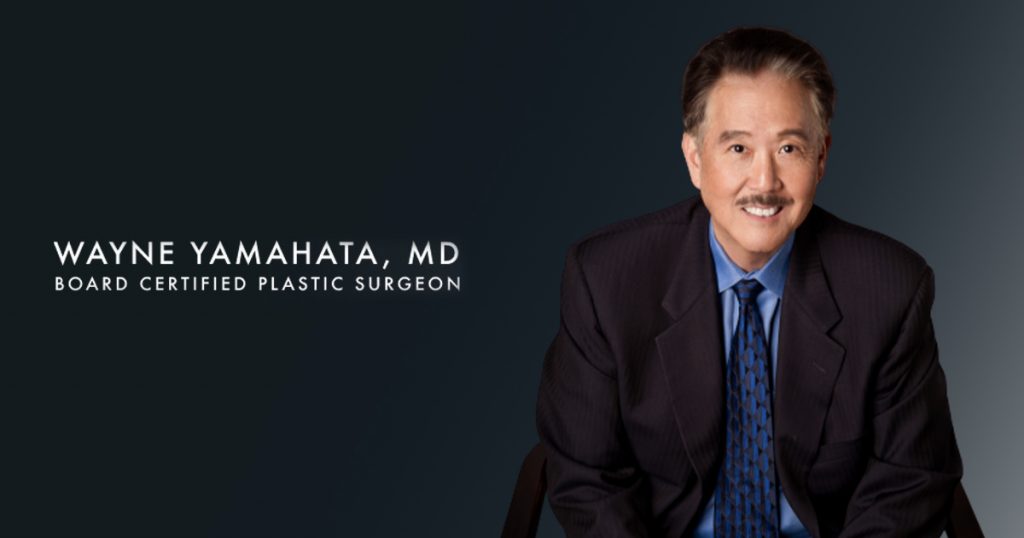 Wayne Yamahata, MD, wearing a dark suit and neck tie smiling next to his name written in text