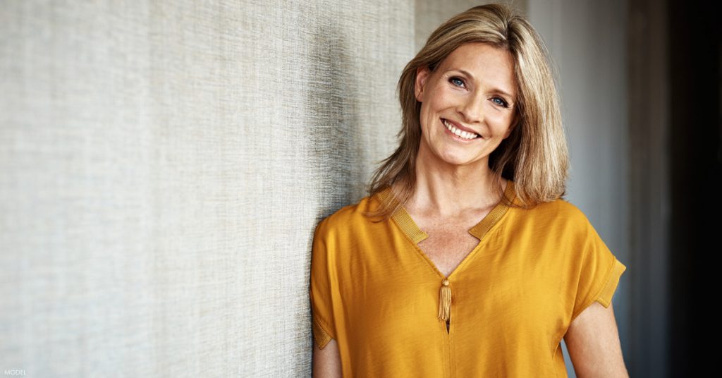 Smiling woman with shoulder length blond hair and head tilted to the right