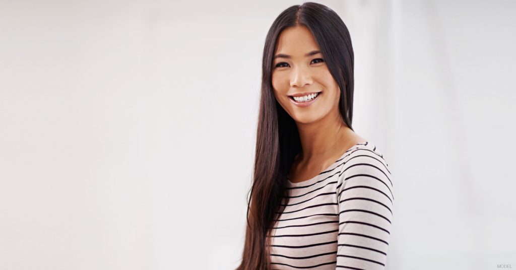 Young woman with long, straight, dark hair smiling